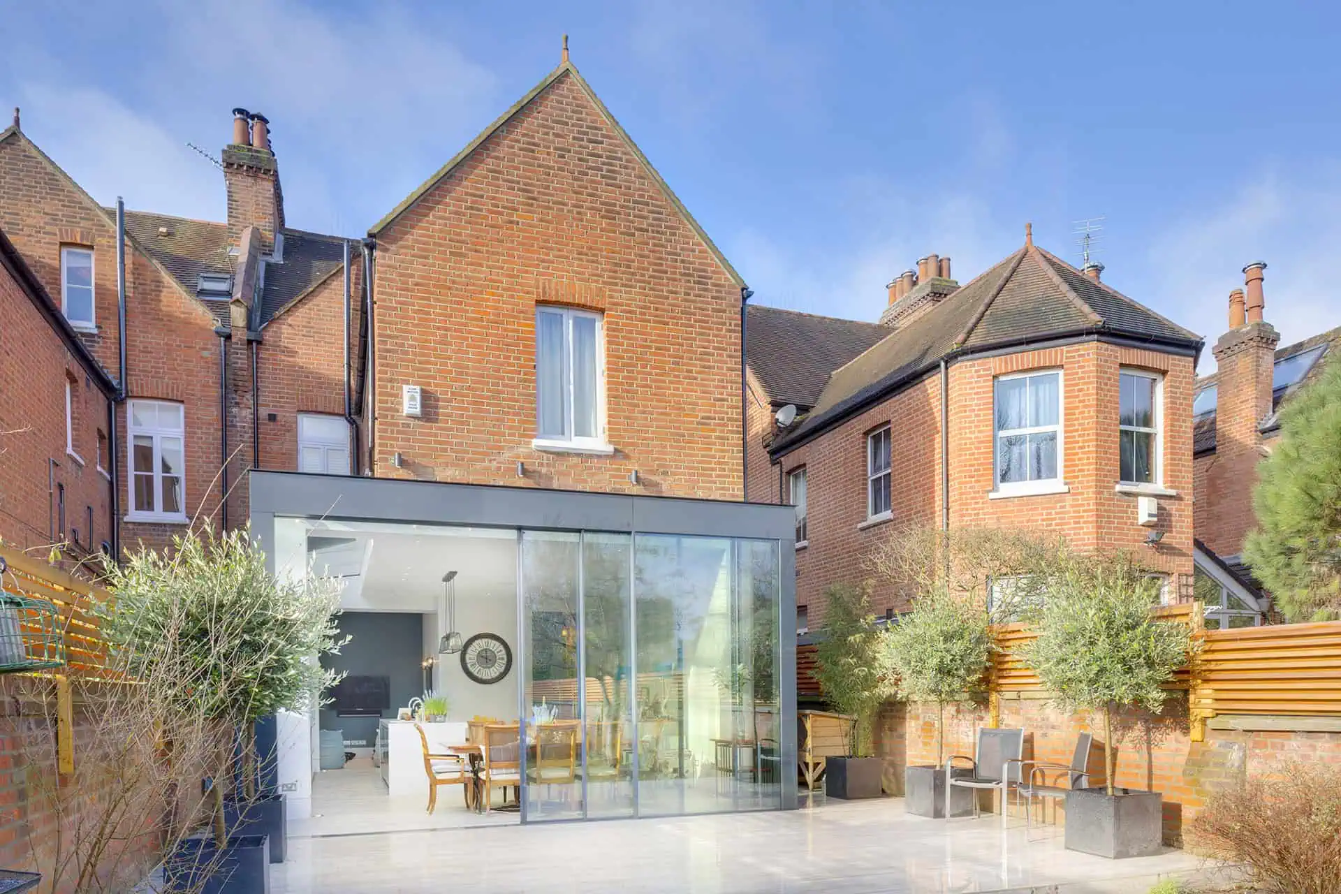 Luxury home extension in Belsize Park featuring modern glass design, spacious dining area, and landscaped outdoor space.