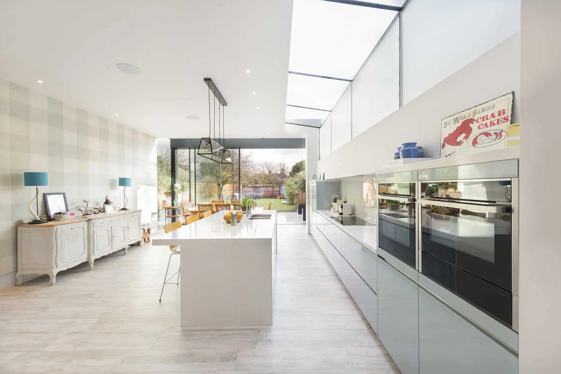 Modern kitchen interior with sleek cabinetry, large island, and ample natural light from glass walls, reflecting luxury new build design in Fulham.